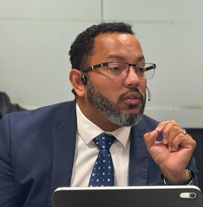 Professional presenting remotely with headset and tablet during an inclusive training or development session.