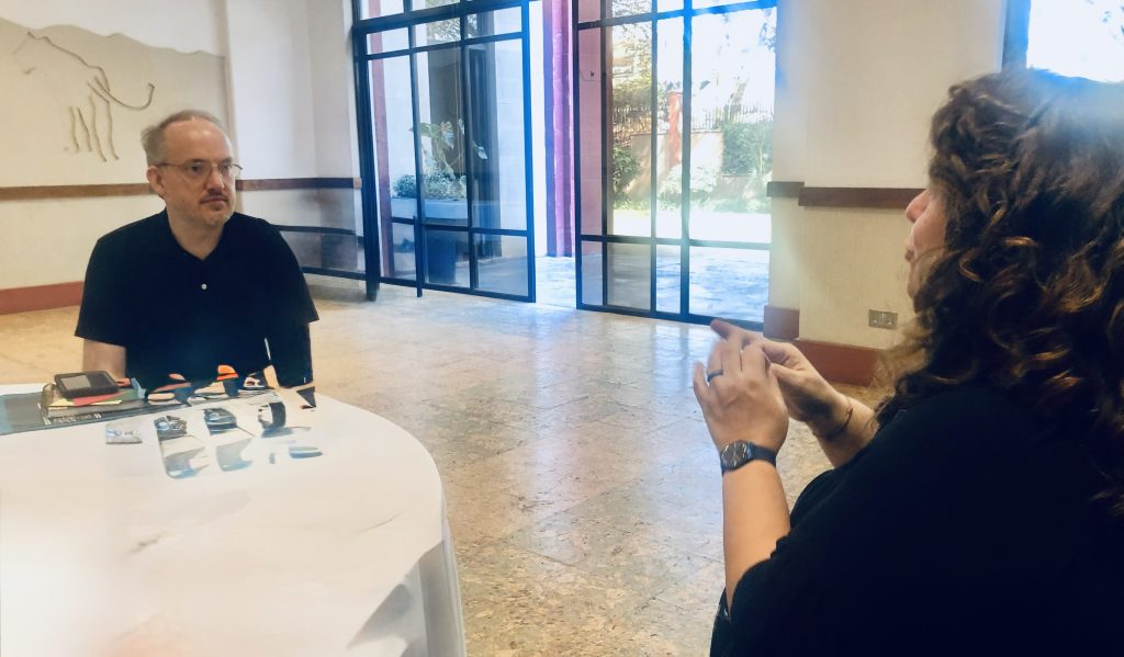 Client seated with an interpreter at a table, discussing tools and strategies.