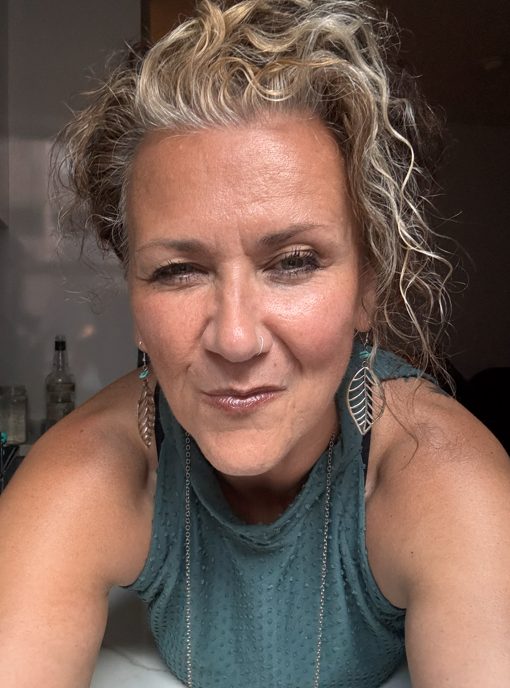 Susie Morgan Morrow smiling indoors, wearing a teal top and earrings.
